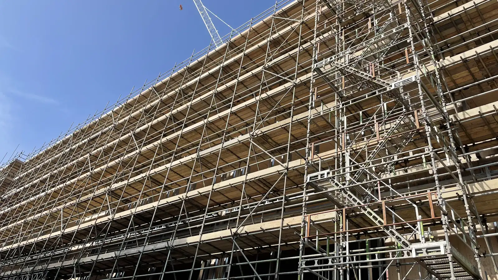 En stor bygning pakket inn i stillas under rehabilitering